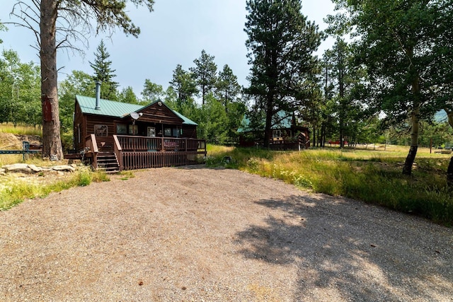 view of yard featuring gravel driveway and a wooden deck