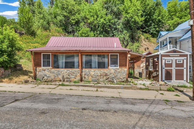 view of front of home with stone siding and metal roof