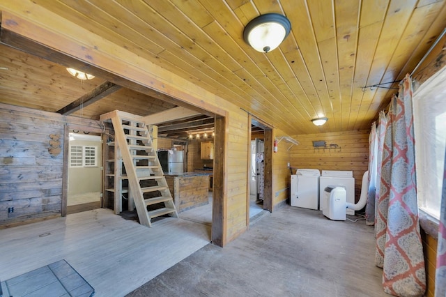 basement featuring wood ceiling, wooden walls, wood-type flooring, independent washer and dryer, and stainless steel refrigerator