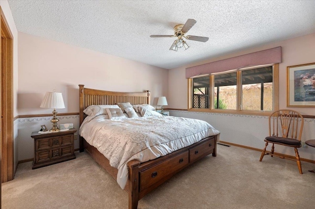 carpeted bedroom with a textured ceiling and ceiling fan