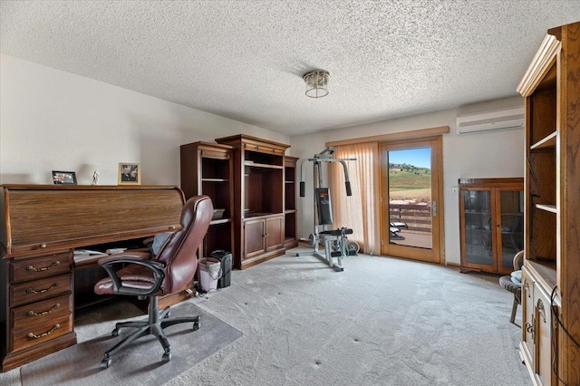 carpeted office featuring a wall unit AC and a textured ceiling