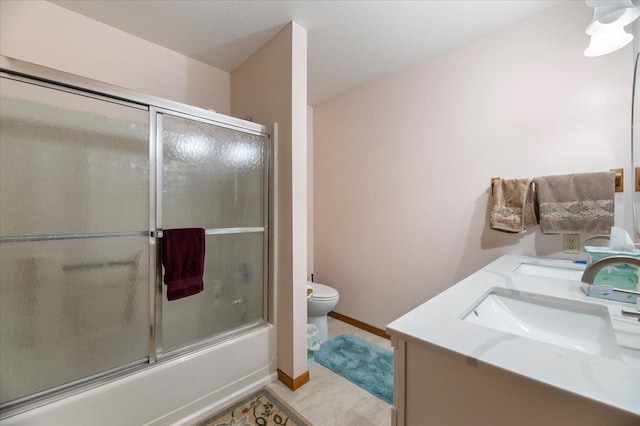 full bathroom featuring toilet, tile patterned flooring, bath / shower combo with glass door, and double vanity