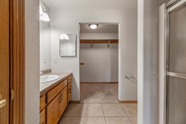 bathroom with vanity, an enclosed shower, and tile patterned flooring