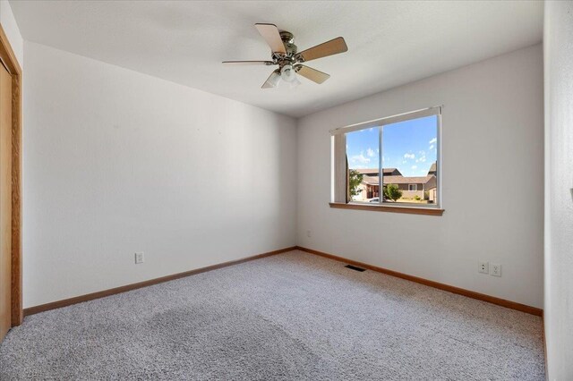 carpeted empty room featuring ceiling fan