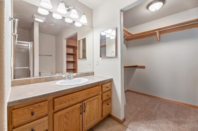 bathroom featuring vanity, toilet, and a shower with door