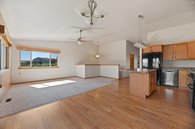 kitchen with decorative light fixtures, stainless steel dishwasher, light wood-type flooring, vaulted ceiling, and a kitchen island