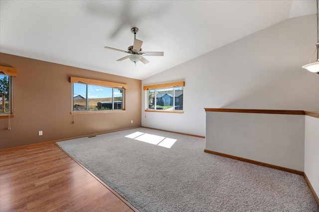 empty room featuring lofted ceiling, hardwood / wood-style flooring, and ceiling fan