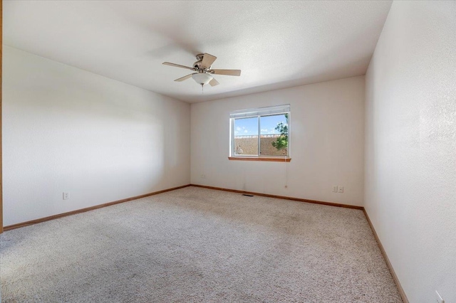 carpeted empty room featuring ceiling fan and a textured ceiling