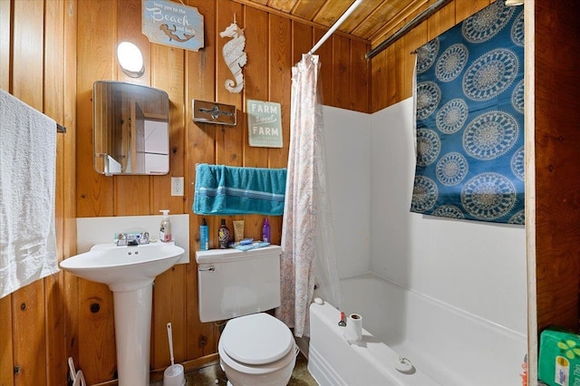 bathroom featuring shower / bath combo with shower curtain, wood walls, and toilet