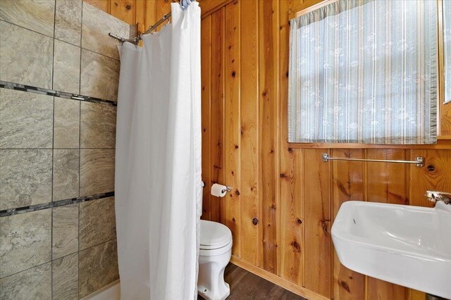 230 N Main St, Spearfish, SD 57783 - full bath featuring toilet, a shower with shower curtain, a sink, wood finished floors, and wood walls