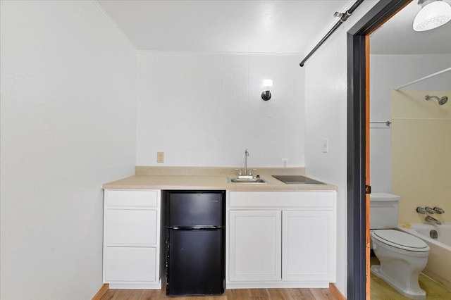 full bathroom with shower / tub combination, toilet, vanity, hardwood / wood-style flooring, and ornamental molding