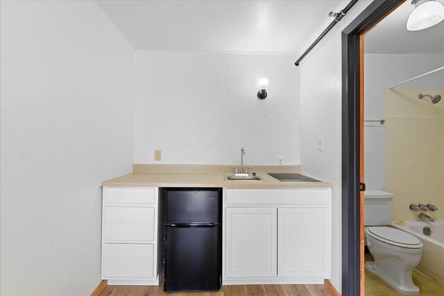 230 N Main St, Spearfish, SD 57783 - indoor wet bar featuring freestanding refrigerator, light wood-type flooring, and ornamental molding