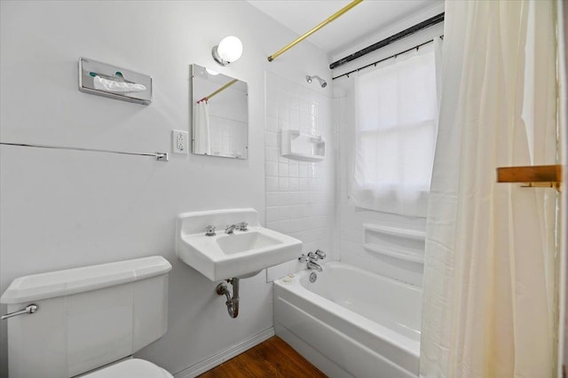 full bathroom featuring hardwood / wood-style flooring, shower / bath combo with shower curtain, toilet, and sink