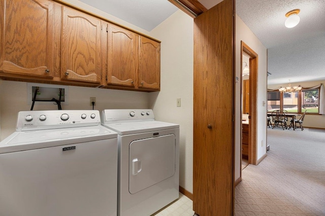 washroom with a notable chandelier, a textured ceiling, independent washer and dryer, cabinets, and light carpet