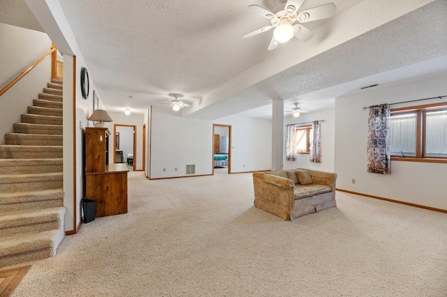 carpeted living room with a textured ceiling and ceiling fan