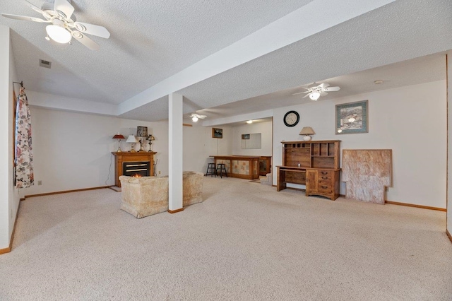 carpeted living room featuring a textured ceiling and ceiling fan