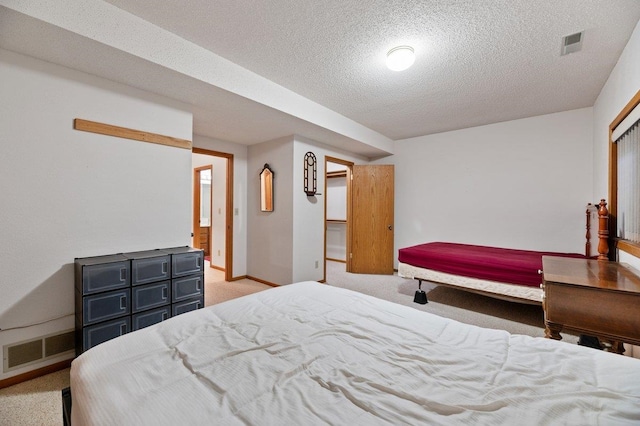 carpeted bedroom with a closet and a textured ceiling