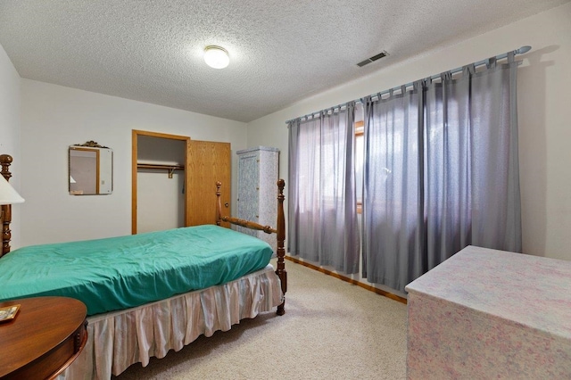 carpeted bedroom featuring a closet and a textured ceiling