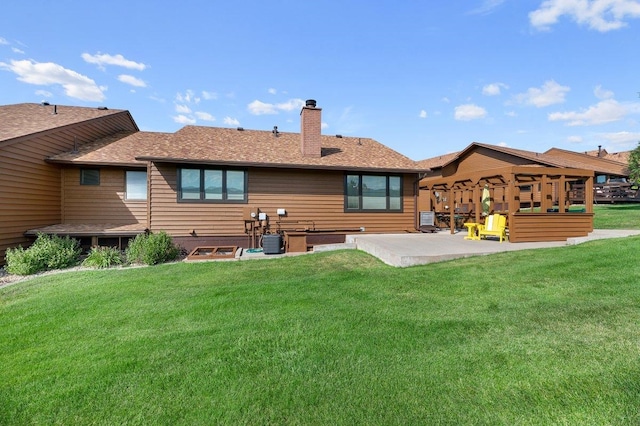 rear view of property featuring a patio, a lawn, and central AC