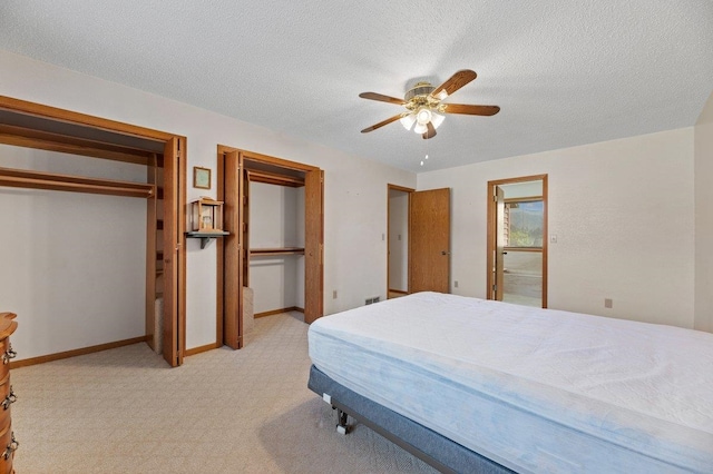 bedroom with a textured ceiling, ceiling fan, and light colored carpet