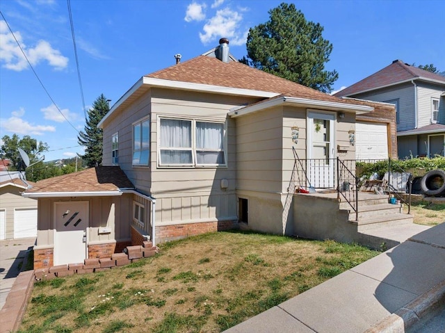 view of front of property featuring roof with shingles and a front lawn