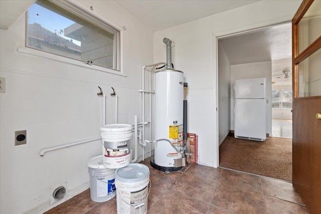 laundry room with tile walls and gas water heater