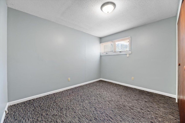 carpeted spare room with a textured ceiling