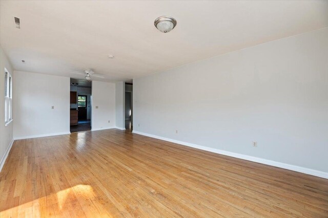 empty room with ceiling fan and light wood-type flooring