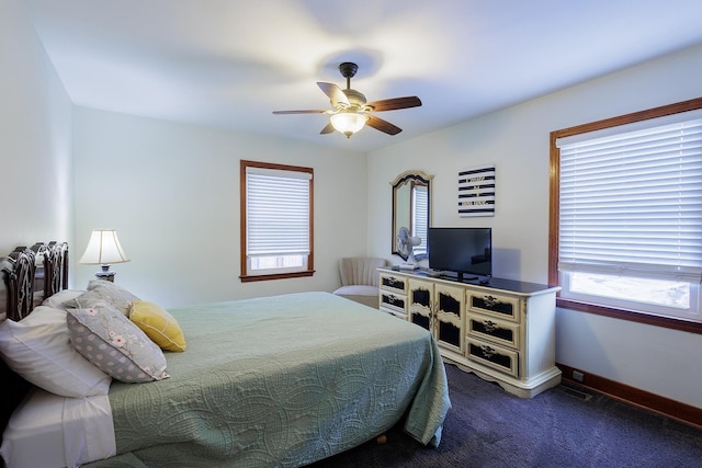 bedroom with baseboards, dark colored carpet, and ceiling fan