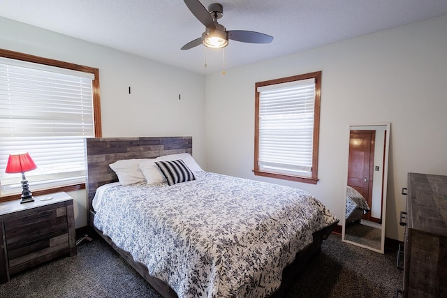 bedroom with a ceiling fan and dark carpet