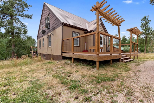 back of house with a wooden deck and metal roof