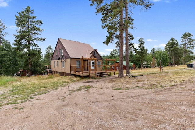 view of front of property featuring metal roof and a deck