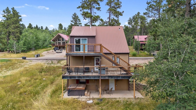 back of house with stairway, a wooden deck, a patio, and metal roof