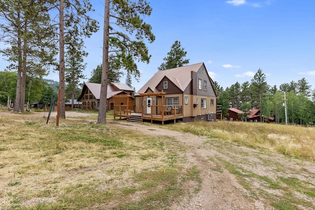 back of house featuring a deck and metal roof