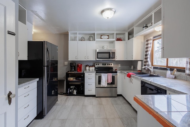 kitchen with open shelves, a sink, stainless steel appliances, tile counters, and white cabinetry