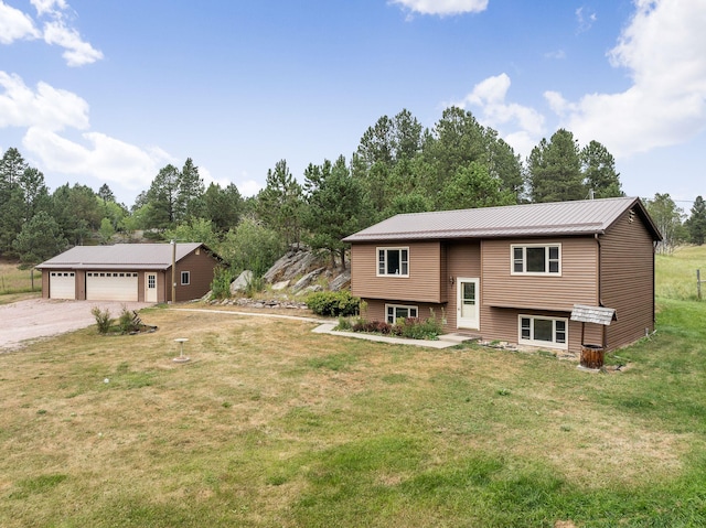 raised ranch featuring a garage, a front yard, and metal roof