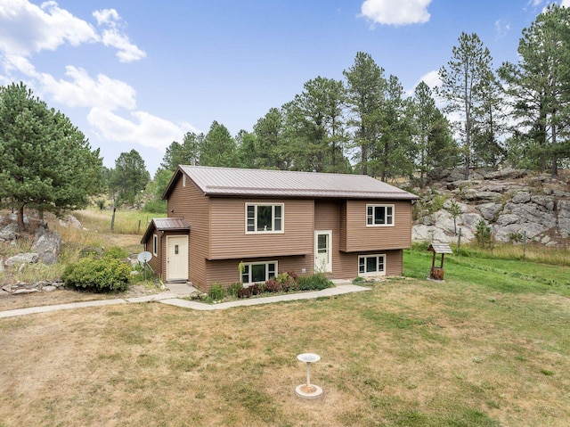 bi-level home with a front lawn and metal roof