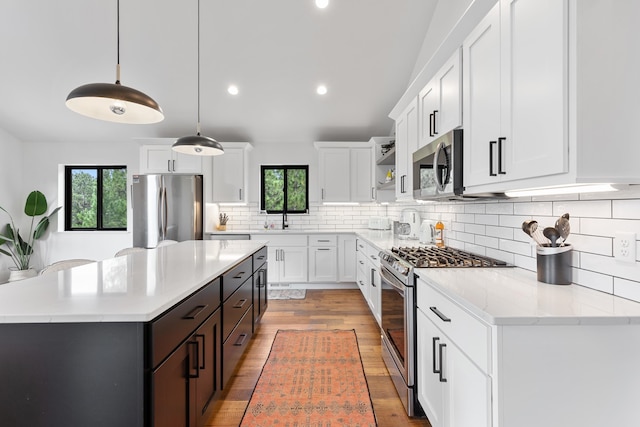 kitchen with tasteful backsplash, light hardwood / wood-style flooring, appliances with stainless steel finishes, and a healthy amount of sunlight