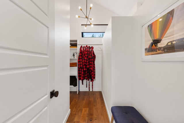 corridor with dark hardwood / wood-style floors and a chandelier