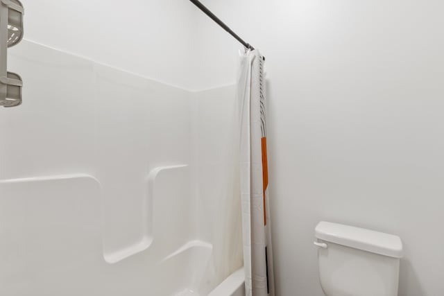 bathroom with shower / tub combo and toilet