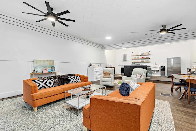 living room featuring ceiling fan and hardwood / wood-style flooring