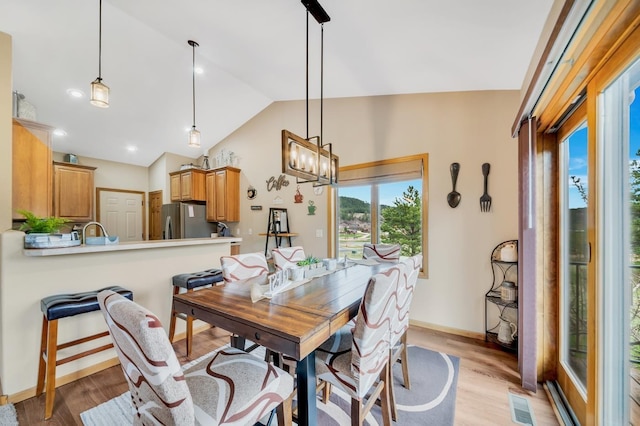 dining area featuring baseboards, an inviting chandelier, vaulted ceiling, light wood-style floors, and recessed lighting