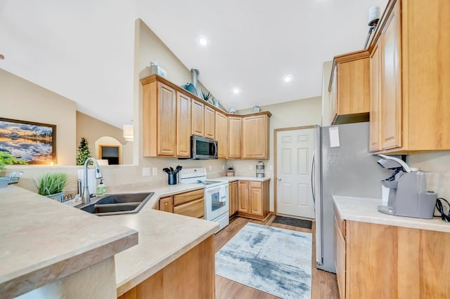 kitchen featuring white electric stove, lofted ceiling, stainless steel microwave, light brown cabinetry, and a sink