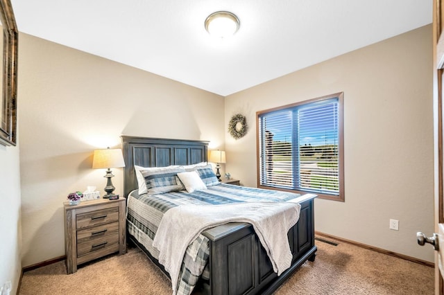 bedroom with light carpet and baseboards