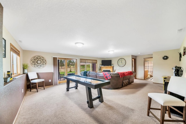 playroom with light carpet, a fireplace, visible vents, and baseboards