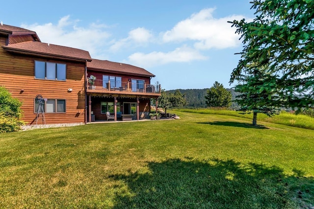 rear view of house featuring a patio area, a lawn, and a wooden deck