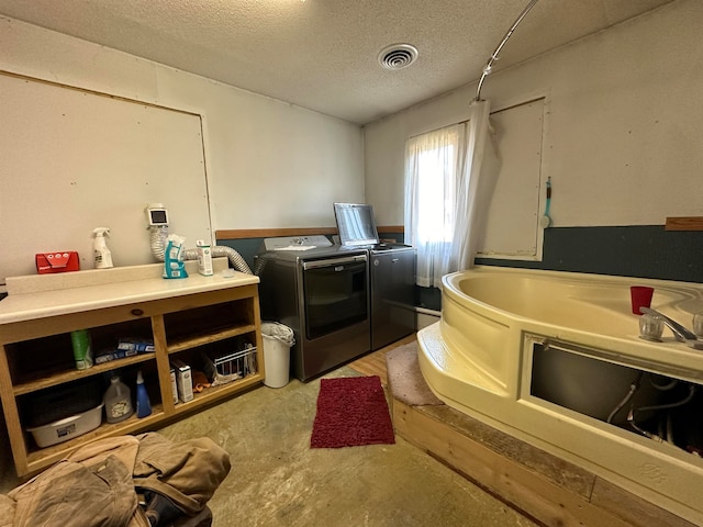 kitchen with independent washer and dryer and a textured ceiling