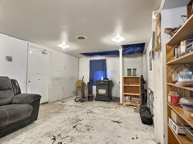 living room with a wood stove and a textured ceiling