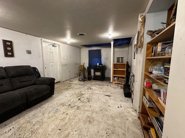 living room featuring a textured ceiling and a wood stove