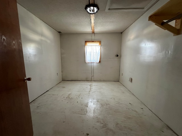 empty room featuring a textured ceiling and concrete flooring